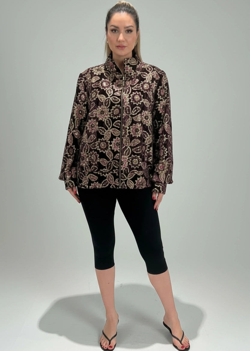 Woman wearing a patterned blouse and black leggings on a gray background