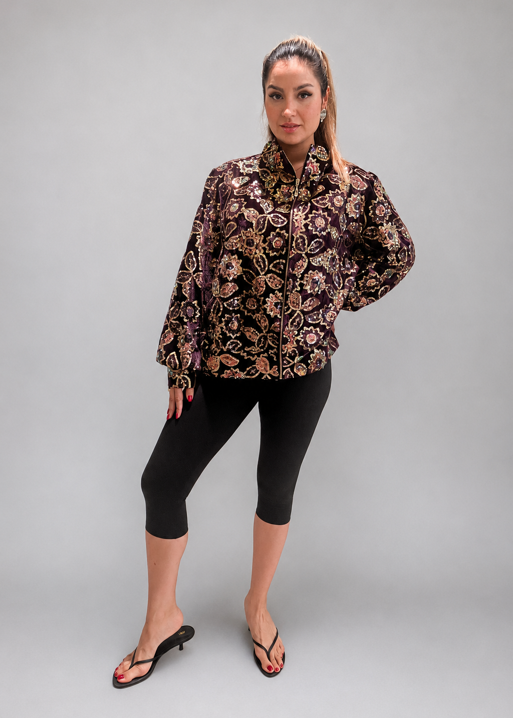 Woman wearing a floral jacket and black leggings indoors.