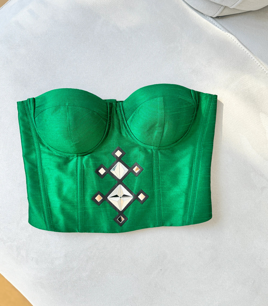 Green crop top with decorative pattern on a white background