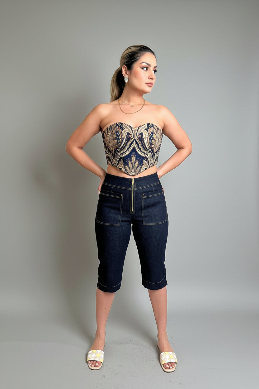 Woman wearing a strapless top with a pattern and high-waisted jeans indoors.