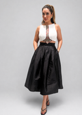 Woman wearing a white top with a black skirt on a gray background